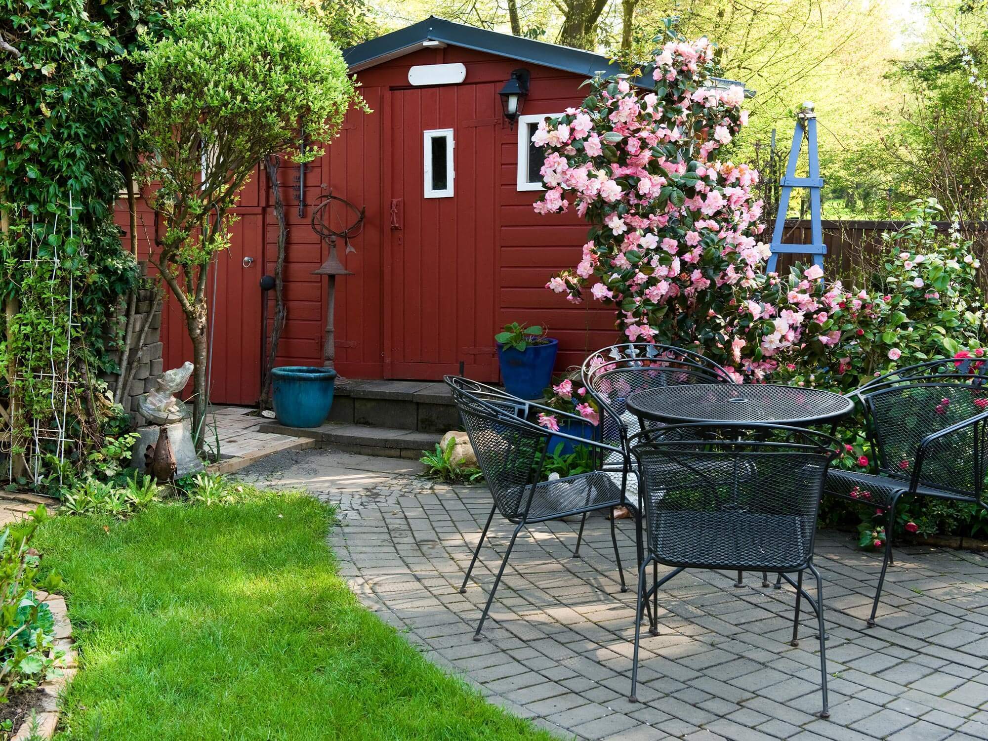 Gartenlaube in einer Schrebergartenanlage mit einer Sitzgruppe und Gehweg