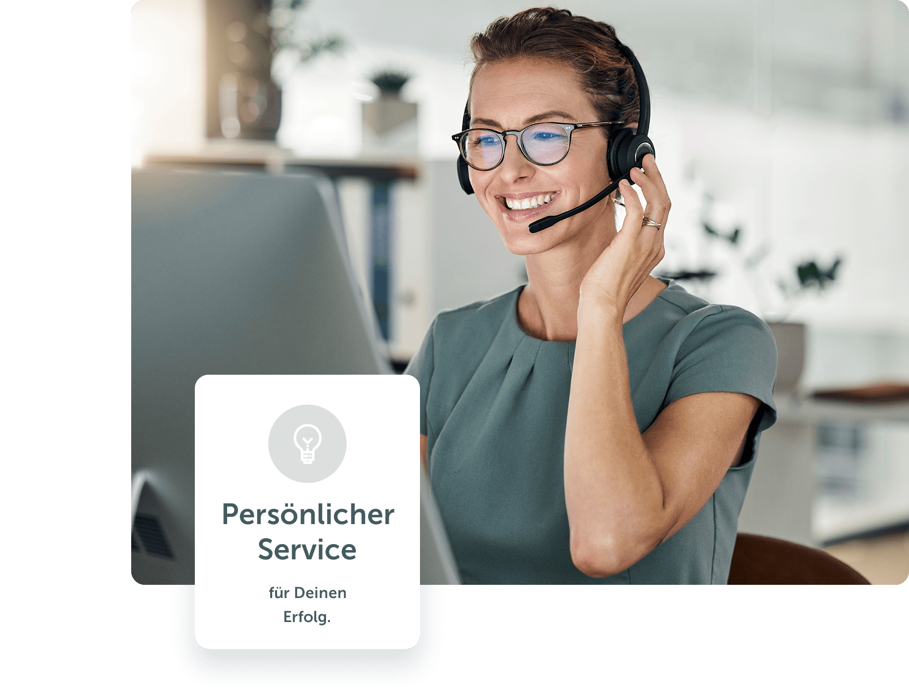 Frau mit Headset sitzt lächelnd vorm Rechner